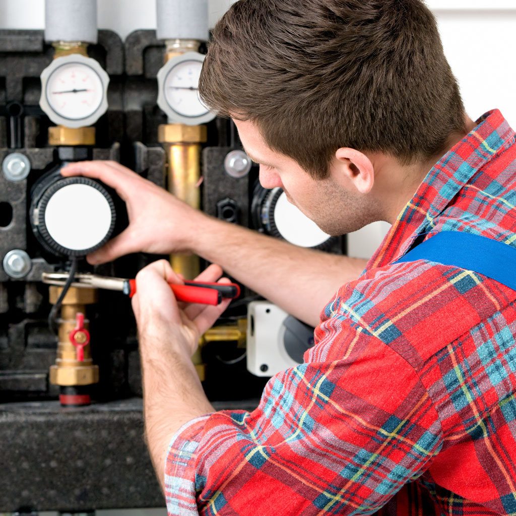Technician servicing heating boiler